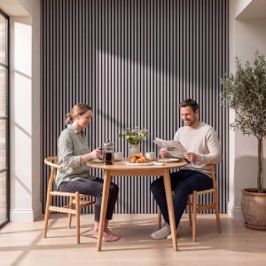 2.4m Alder Grey Wall Panels installed vertically behind a breakfast table in a bright modern dining nook.